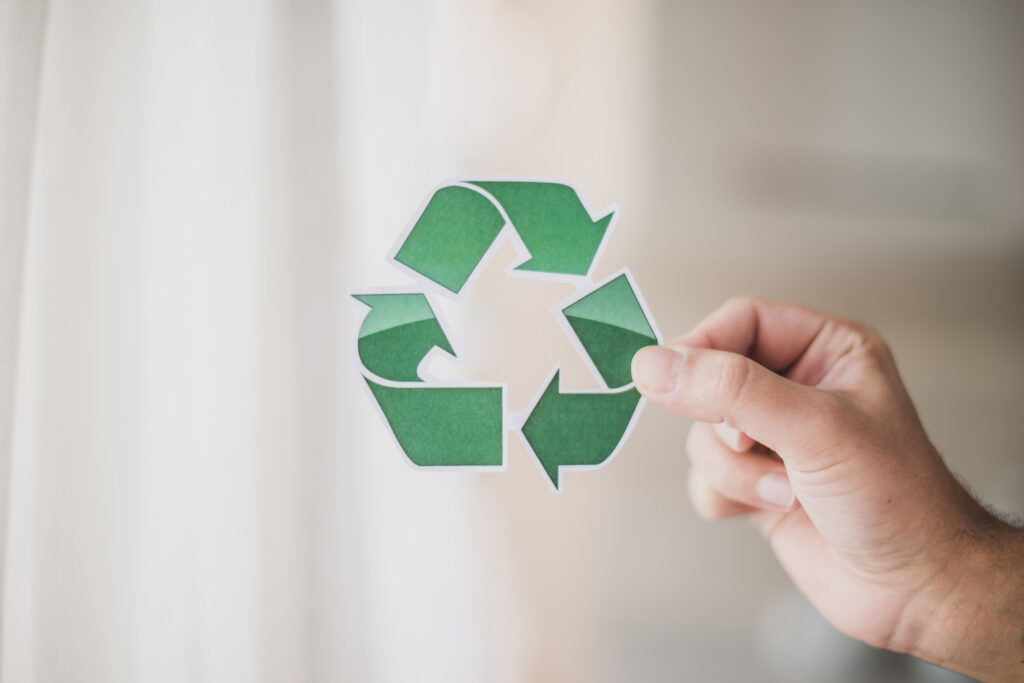 man s hand showing recycle icon